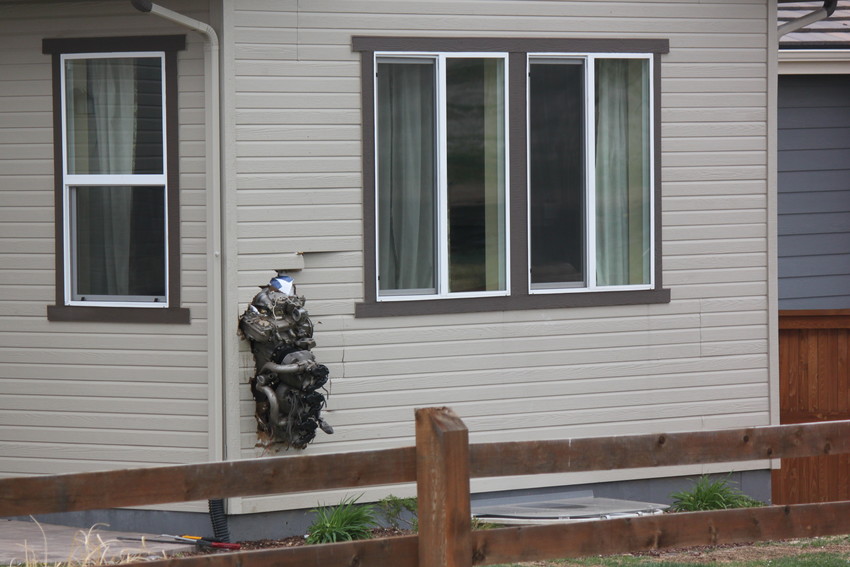 The engine of an SR22 plane that crashed around 8:30 May 11 was propelled several hundred yards and embedded into a home nearby the crash site, just west of the Stepping Stone neighborhood. Photo by Tabatha Stewart